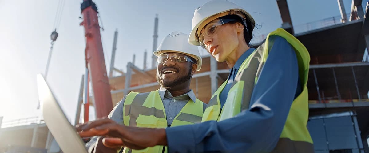 Two construction works looking at a laptop