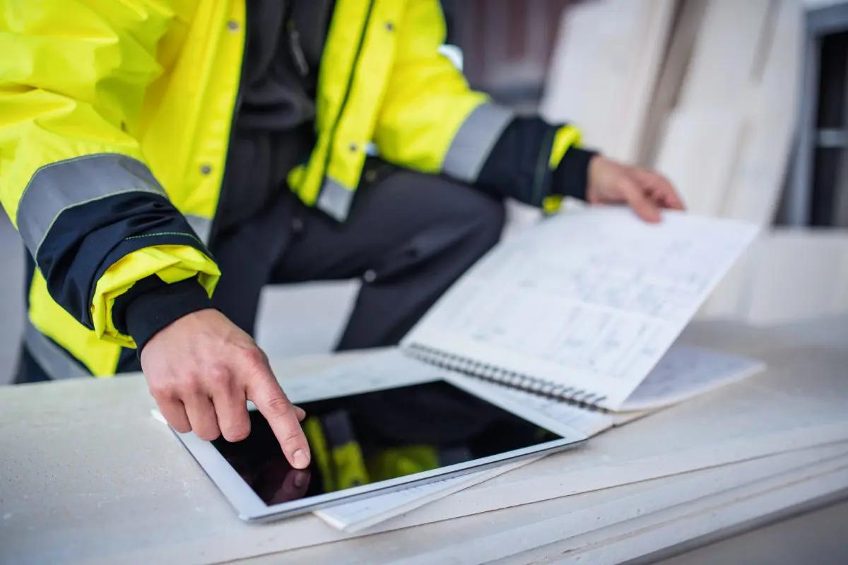 Construction worker pointing at an iPad 1200x800