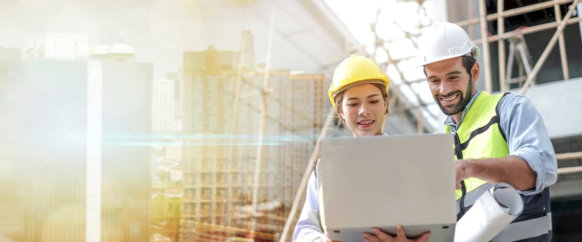 Two construction workers looking at a laptop