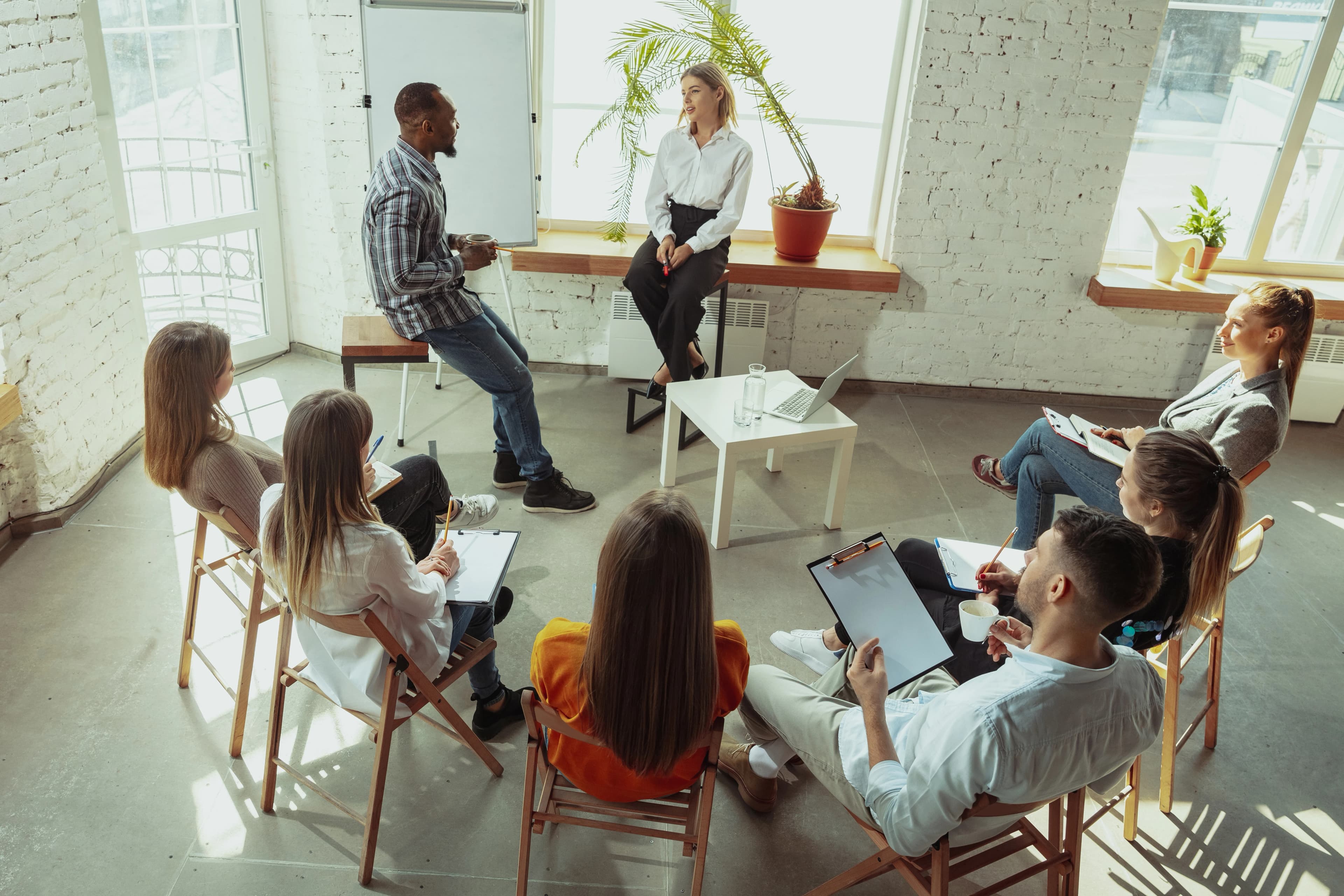 Employees sitting listening to two people talk