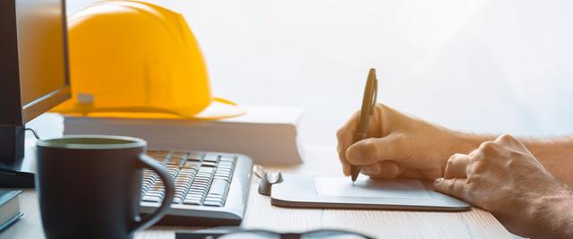 Yellow helmet on a desk next to a monitor