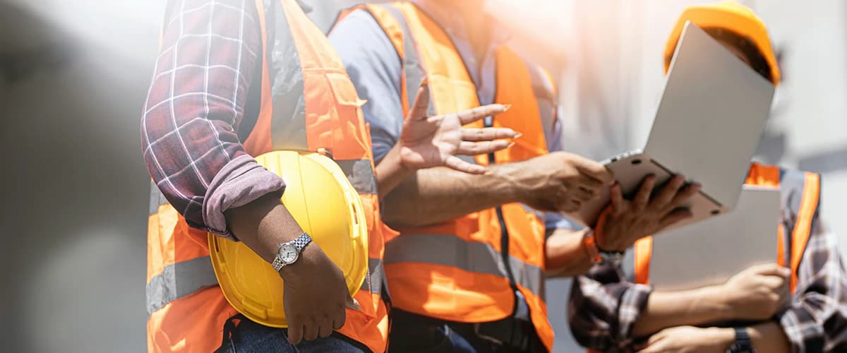 Three holding workers with safety vests