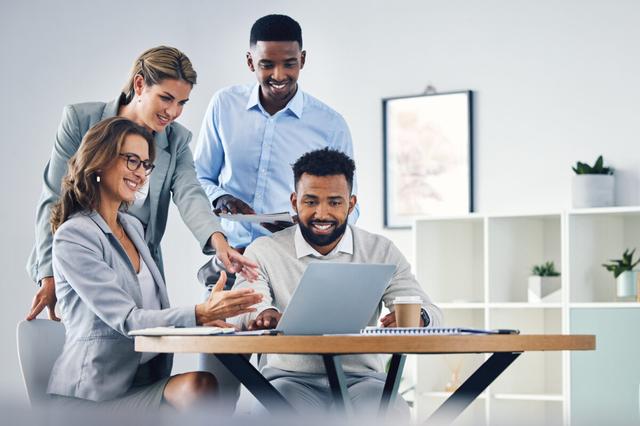 Four construction workers looking at a monitor 1200x798