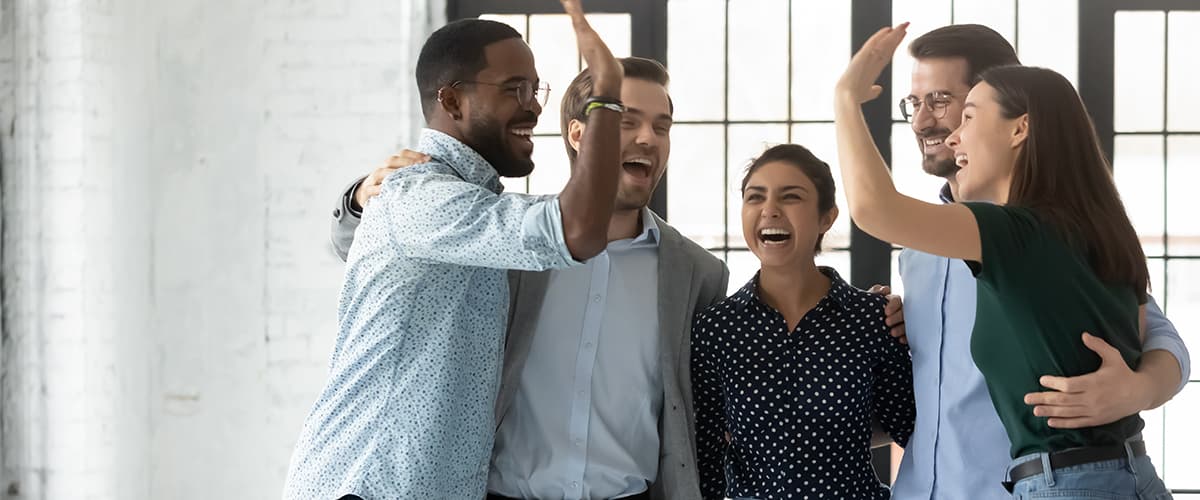 Five employees happy and high fiving