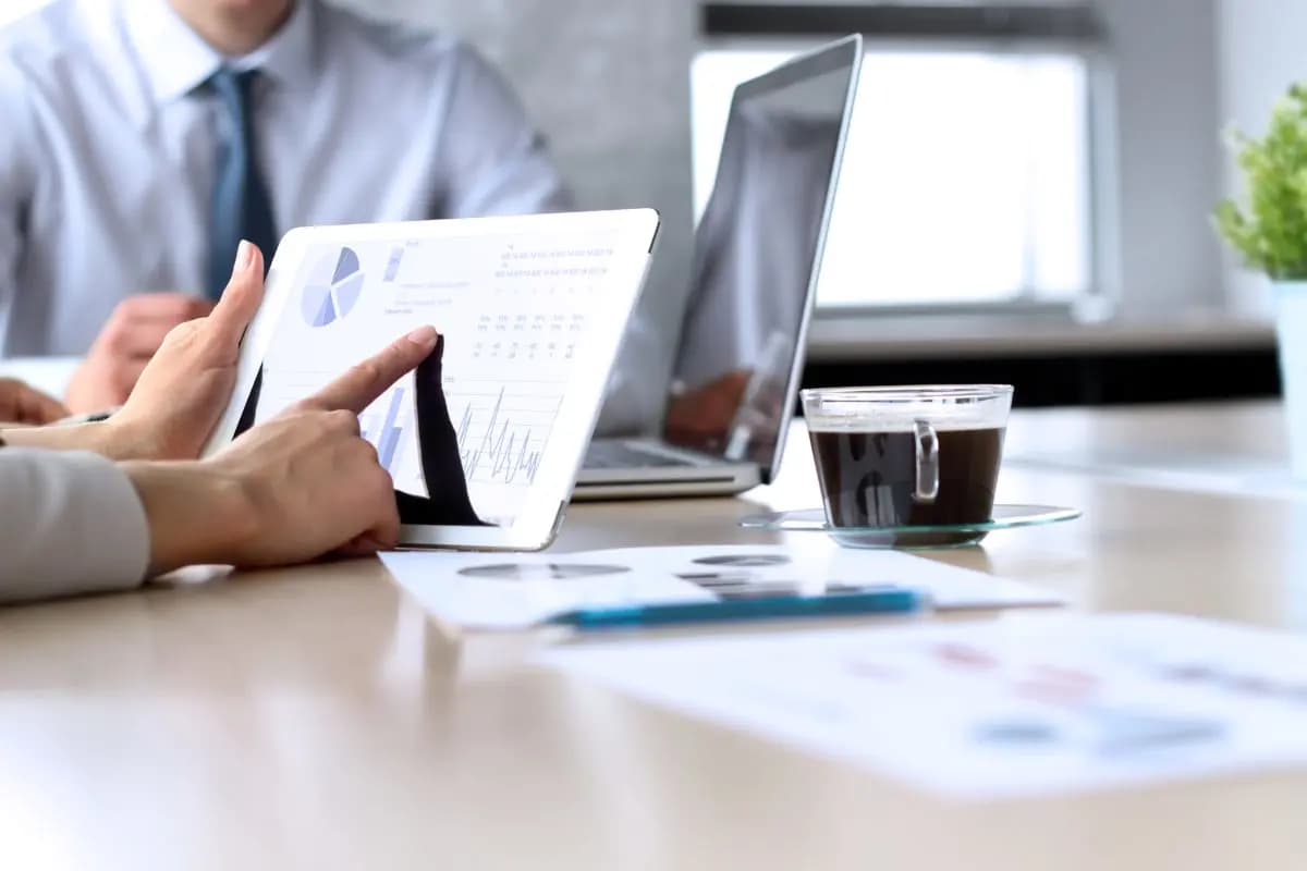 Graphs and charts on an iPad and papers on a desk 1200x800