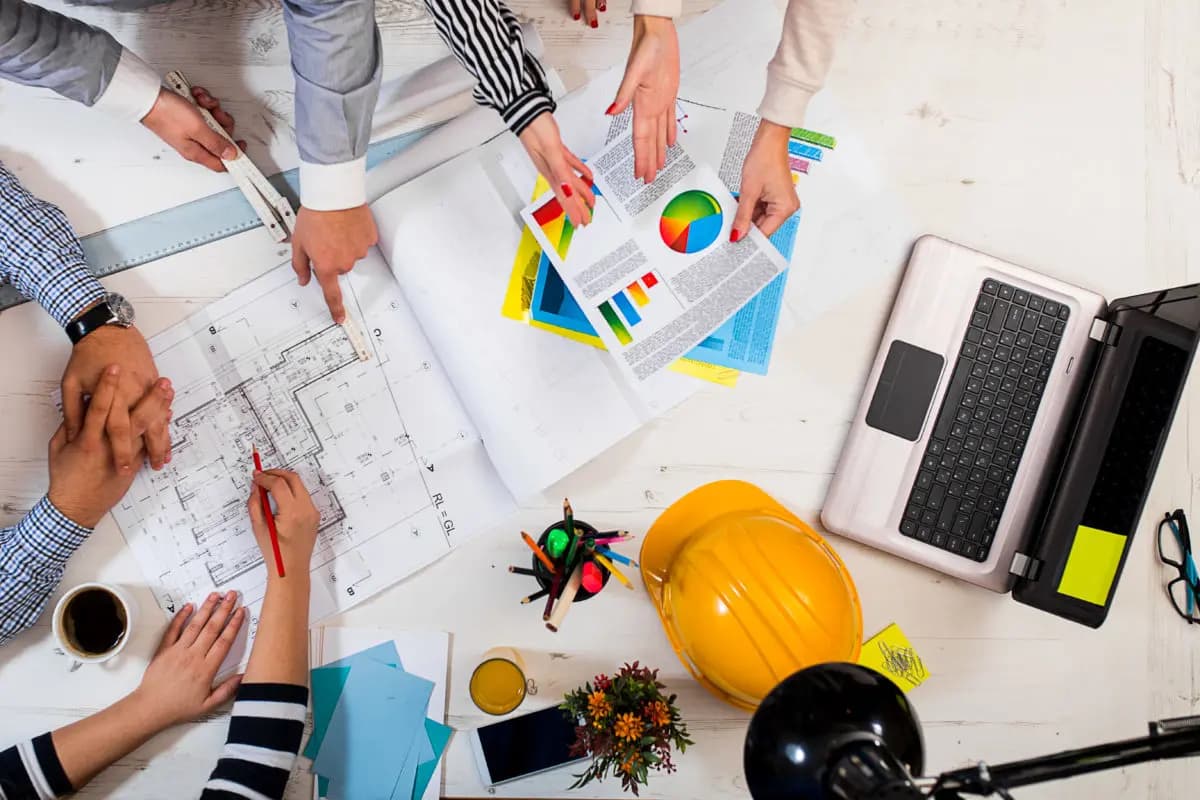 Over head shot of executives looking at drawings and chart 1200x800