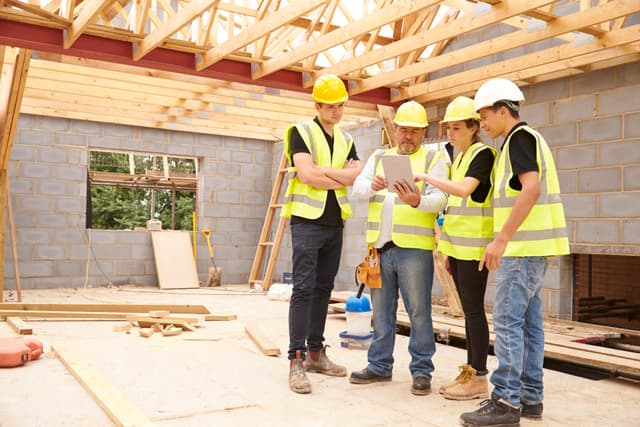 Four construction workers looking at an iPad- 1200x800