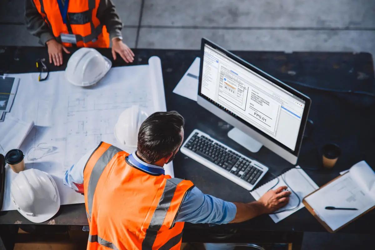 overhead shot of construction worker looking at monitor