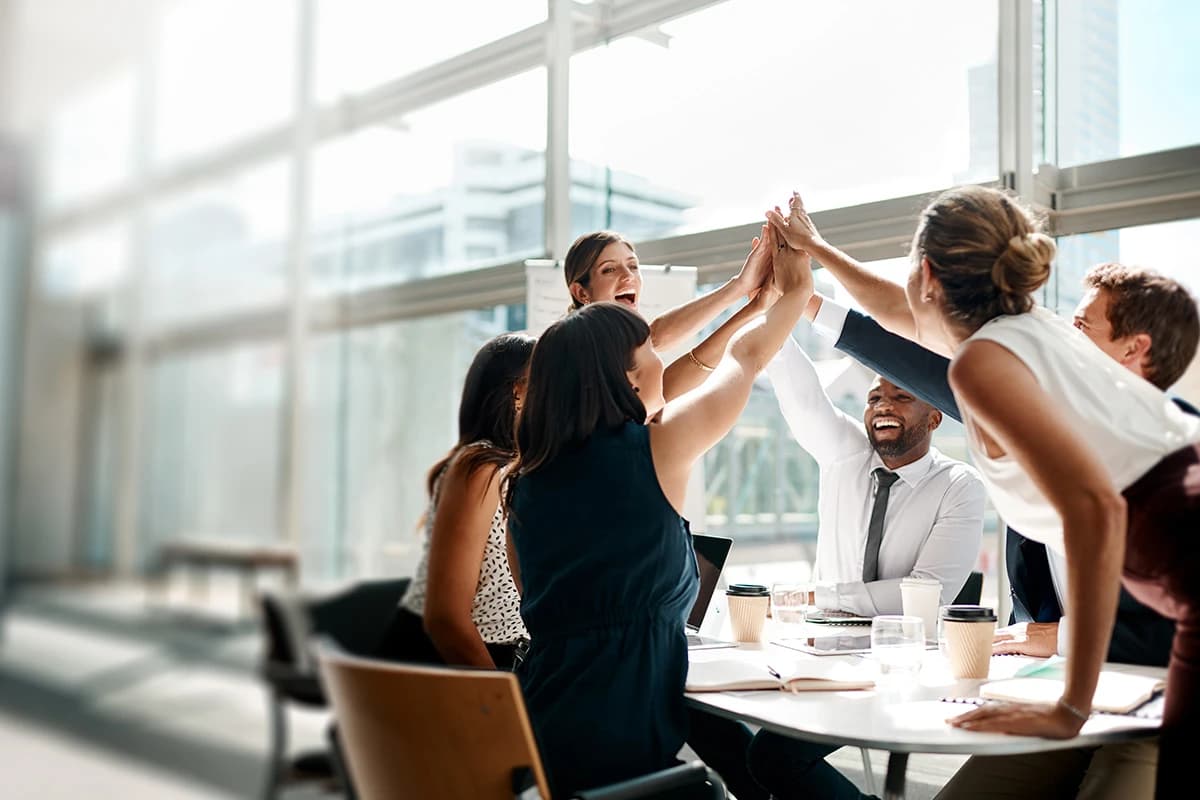 Employees high fiving in a group