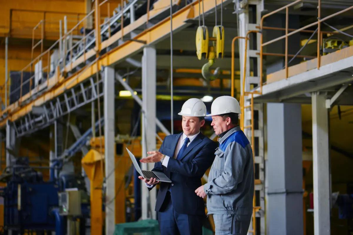 Two executives on a site looking at a laptop 1200x801